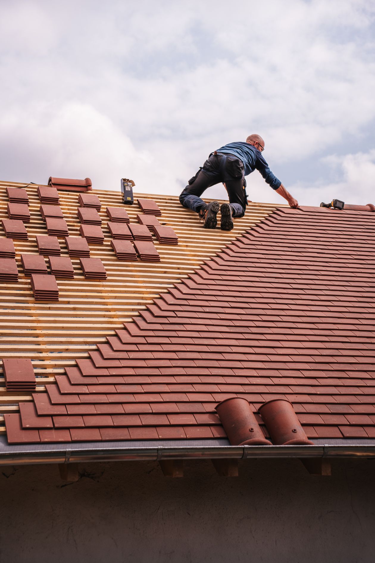 Faircloth Roofing craftsman laying roof tiles during a re-roofing project